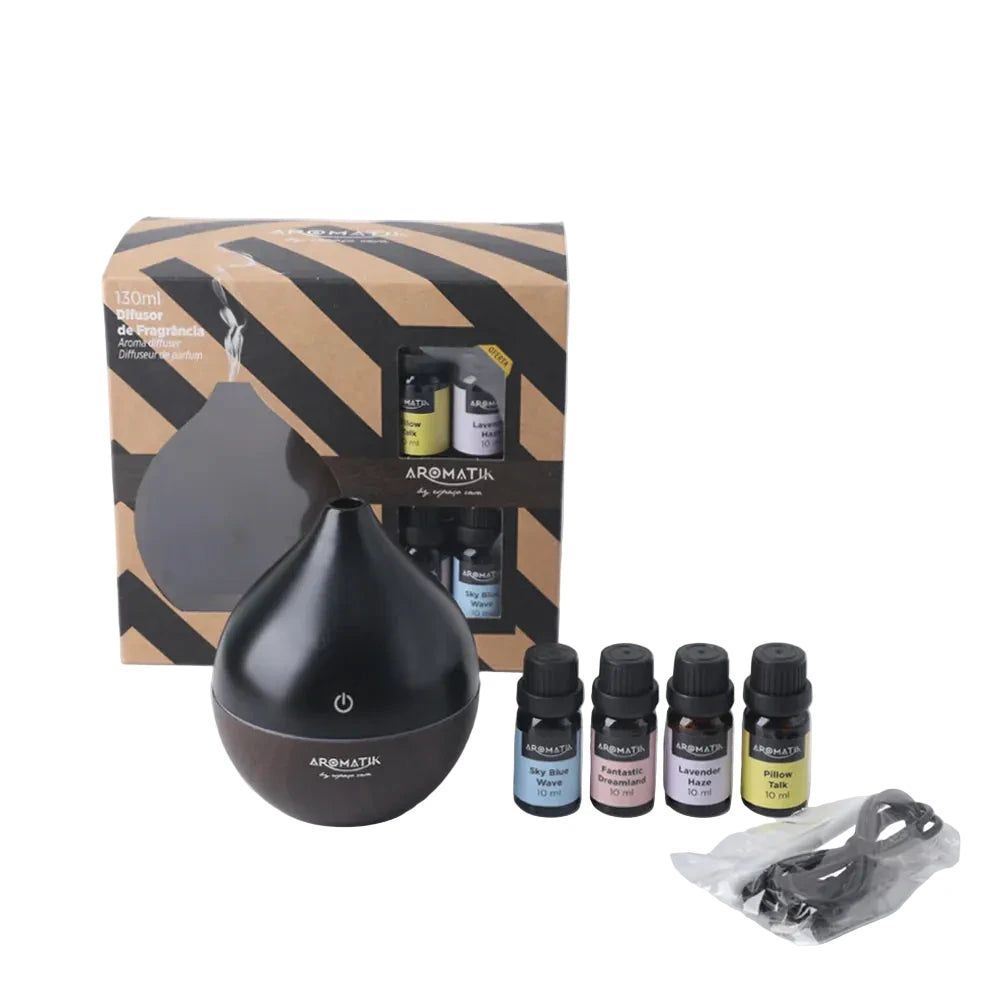 Black essential oil diffuser with packaging and bottles on a white background