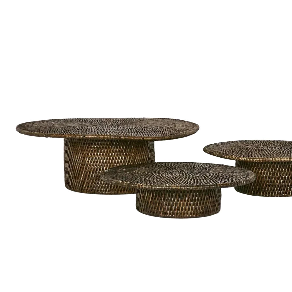 Set of three woven rattan coffee tables on a white background
