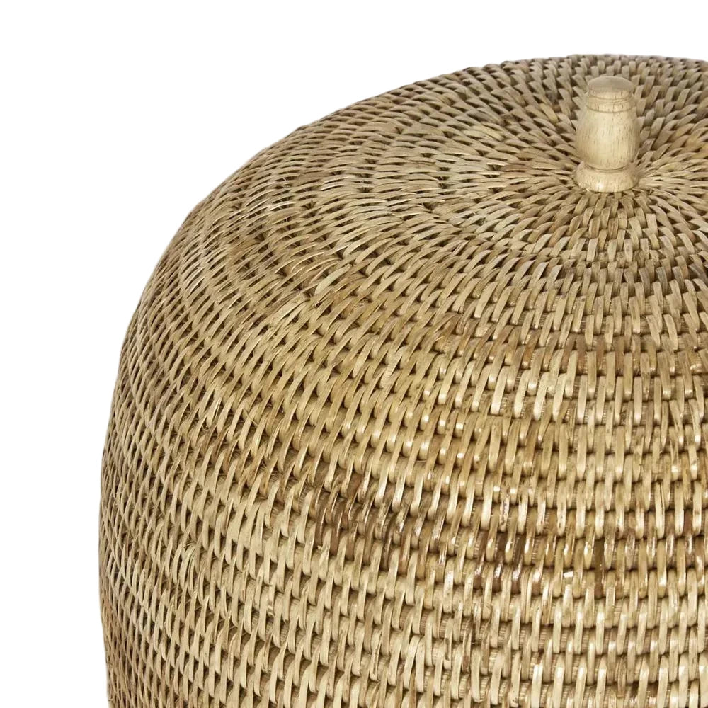 Close-up of a woven rattan ottoman on a light gray background