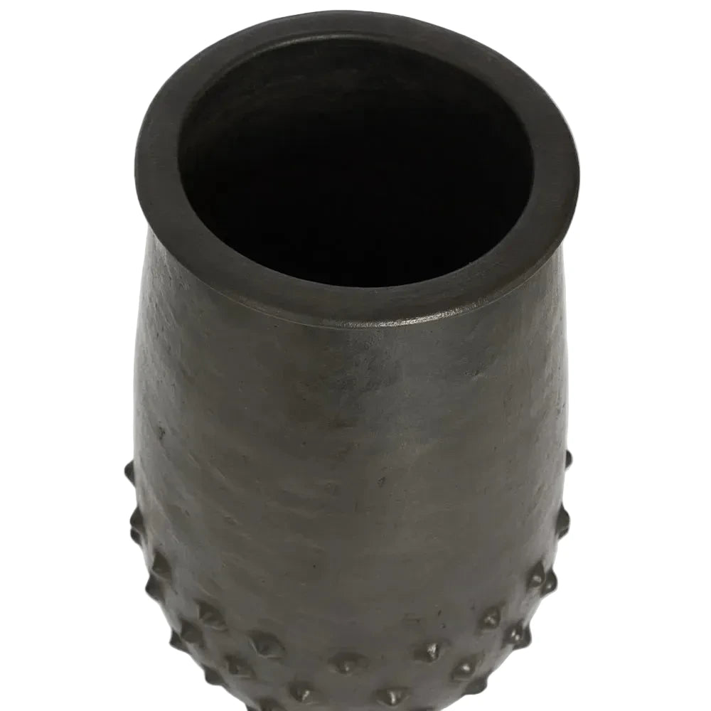 Black textured vase with a ribbed surface on a light gray background