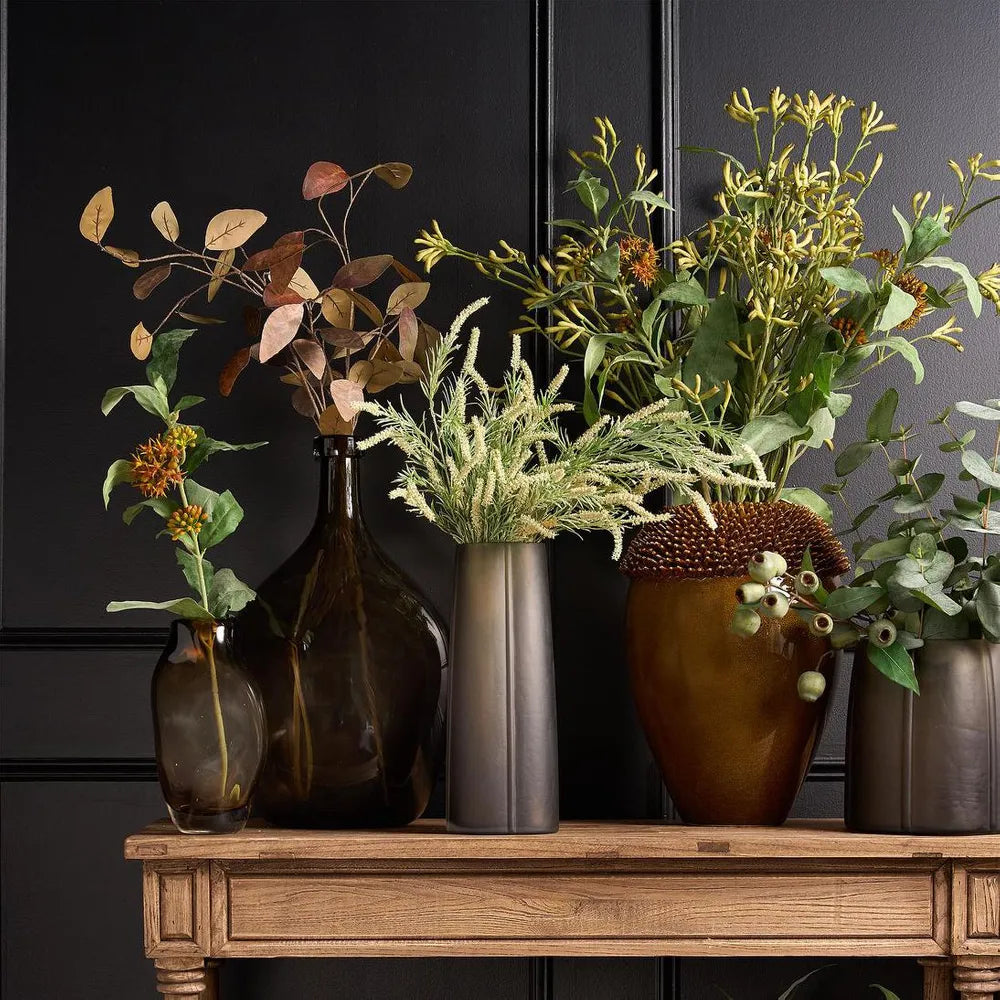 Decorative arrangement of potted plants on a wooden surface with a dark background