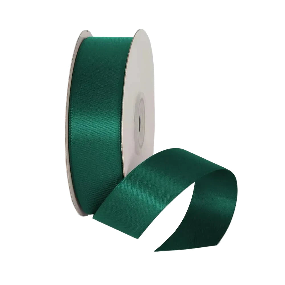 Roll of green satin ribbon on a white background