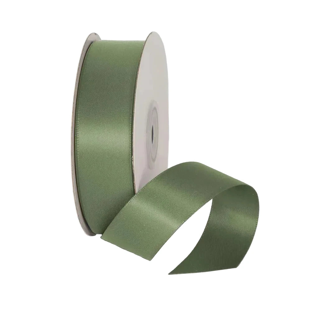 Spool of green ribbon on a light gray background