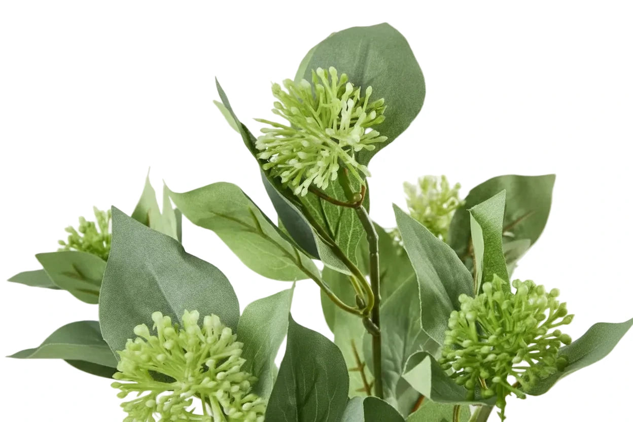 Close-up of green artificial flowers and leaves on a light background