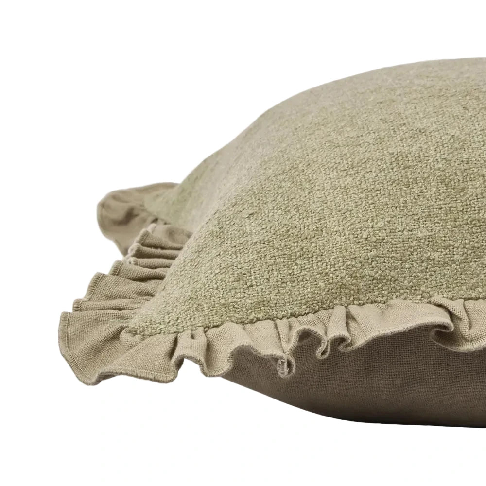 Green cushion with ruffled edge on a light gray background