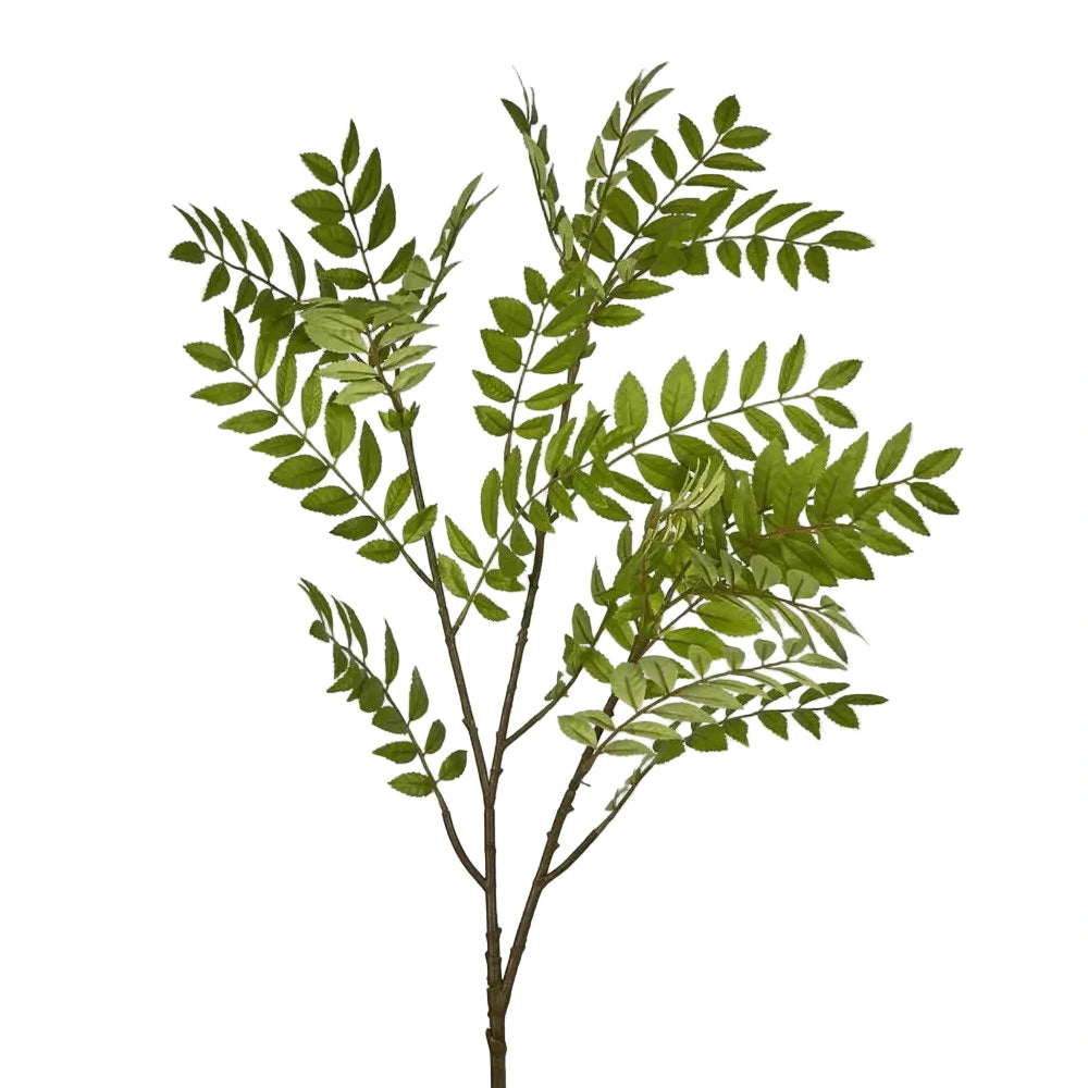 Artificial green leaf branch on a light gray background
