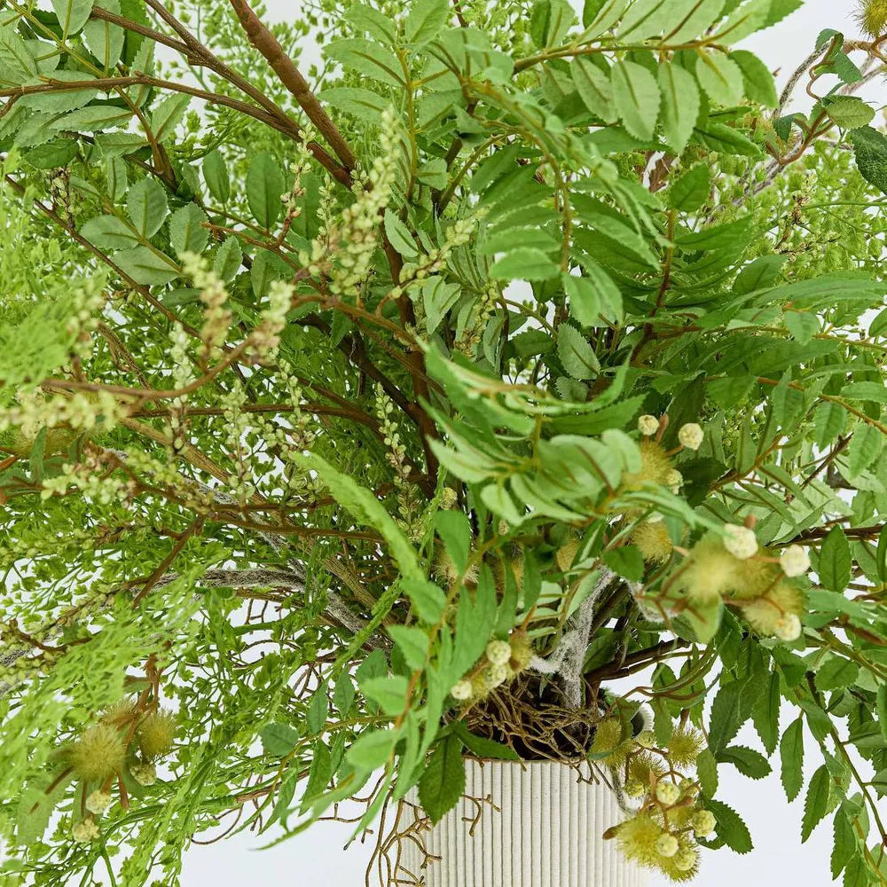 Artificial green plant with branches and leaves on a white background