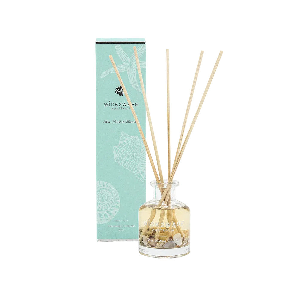 Reed diffuser set with bottle and sticks next to packaging on a white background