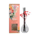 Wickware Australia diffuser set with floral packaging and clear vase with sticks and flowers.