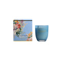 Blue candle with floral packaging on a white background