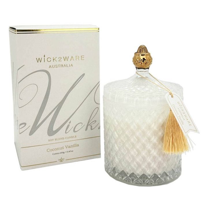 Candle with decorative packaging and tassel on a white background