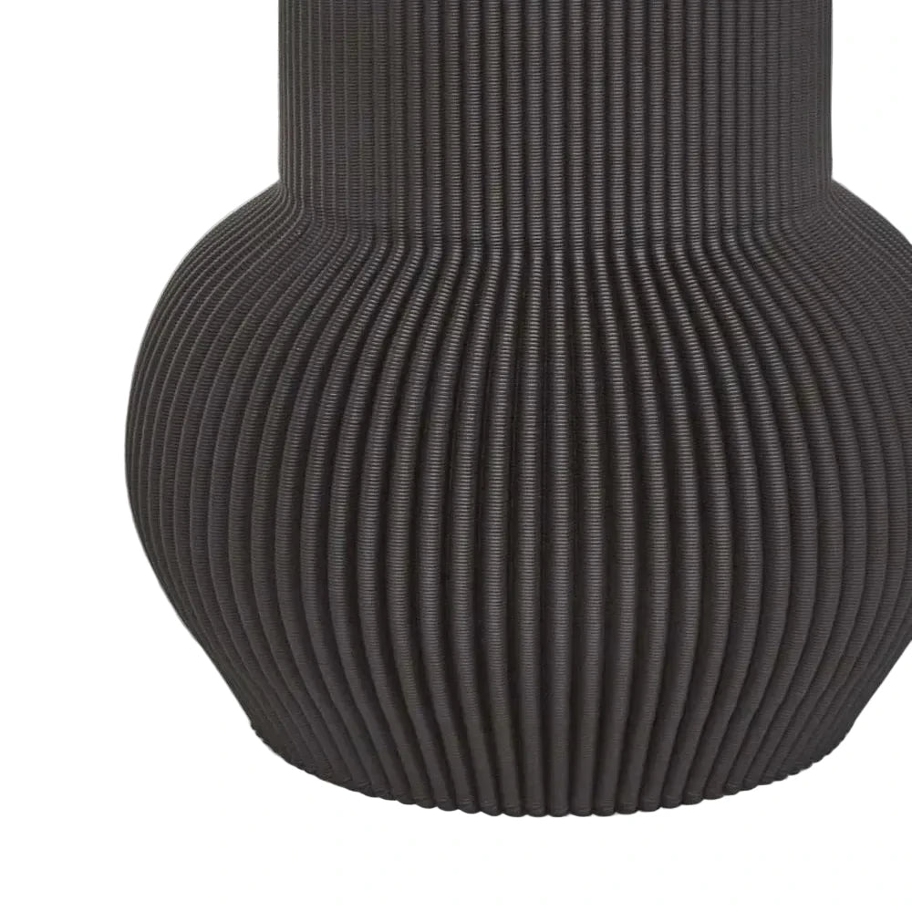 Black ribbed vase on a light gray background